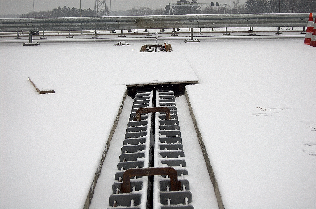 20100214-165347.bmp - Geplaatste en meteen weer ondergesneeuwde nieuwe voegovergang. Genoemde aggregaten zullen, behalve voor schaftkeetverwarming, wellicht gaan dienen om het uithardingsproces van de betonachtige substantie waarmee de voegen worden gefixeerd, veilig te stellen. Zo'n werkwijze zagen we ook al bij  de andere aannemer in Ekkersrijt .  week 201005 