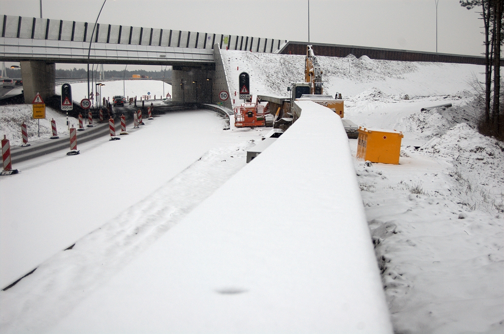 20100214-172349.bmp - Een aantal betonnen sierelementen neergelegd op het geluidsschermpje langs de parallelrijbaan nabij KW 33. Voormalige bypass nog niet helemaal afgegraven, zodat de werkverkeerdoorgang verdere afbouw nog verhinderd.  week 201005 