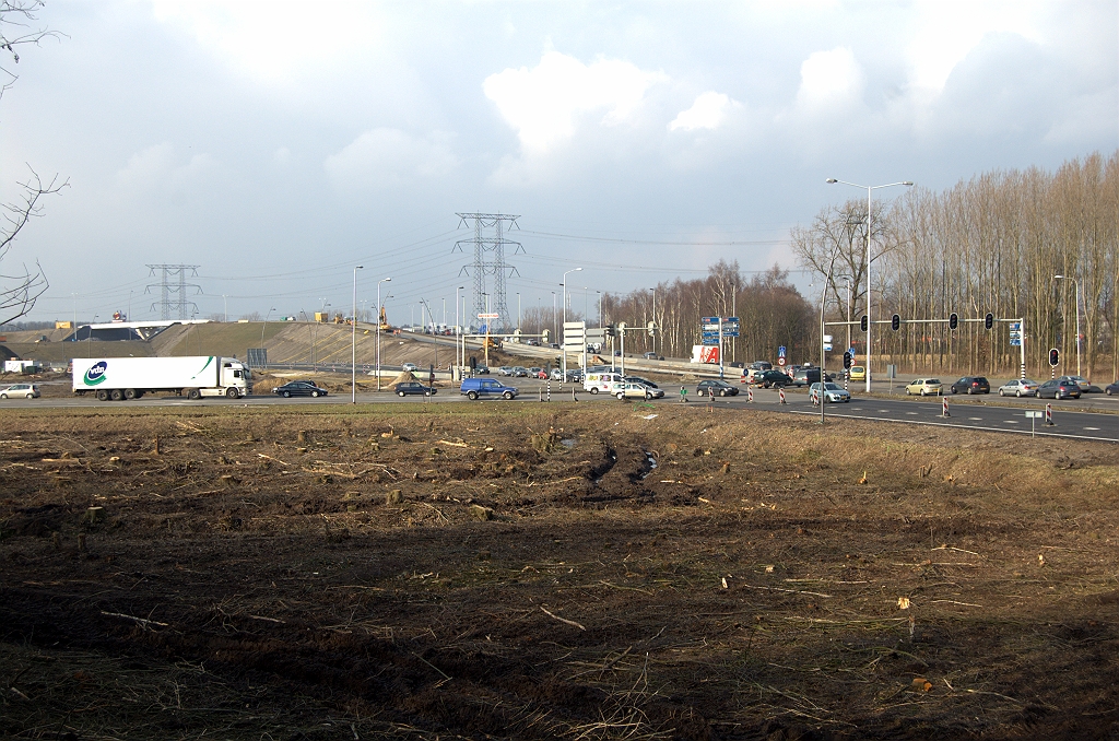 20100220-160520.bmp - Bosperceel gekapt in de zuidwest oksel van het kruispunt A50/A58 in Ekkersrijt (met dank aan Marcos5 voor de opmerkzaamheid). De kap is sowieso nodig voor de herinrichting van het gebied, waarbij de geluidswal (standpunt) naar het noorden wordt verplaatst om ruimte te scheppen voor woningbouw. Dat zijn zaken voor als het wegenbouwproject is afgerond - waarom dan nu al de kaalslag?