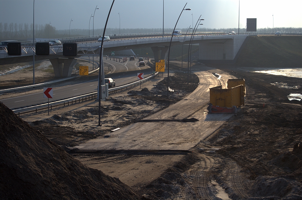 20100220-173420.bmp - Het hoofd ongeveer 120 graden gedraaid waar de eerste lagen asfalt voor het ontbrekende gedeelte parallelrijbaan naar KW 4C al gereed liggen. Na voltooing kan het oversteekje bij KW 5 worden verwijderd, en de A2 hoofdrijbaan teruggebracht naar twee rijstroken met vluchtstrook.  week 201005 