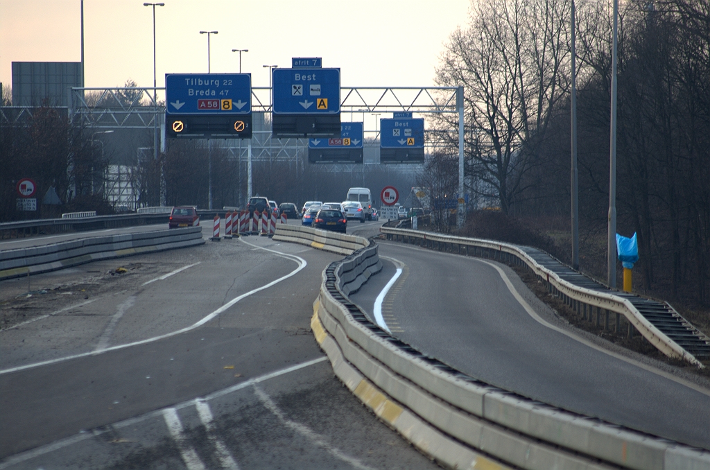 20100220-174606.bmp - Samenkomst met de A58 hoofdrijbaan vanuit de richting Maastricht. Hopelijk niet te veel problemen voor verkeer dat niet de afrit Best wil nemen, alhoewel de situatie niet wezenlijk anders is als in de vorige fasering. Tussen de barriers werkruimte voor de aanleg van de definitieve verbindingsweg Nijmegen-Breda.