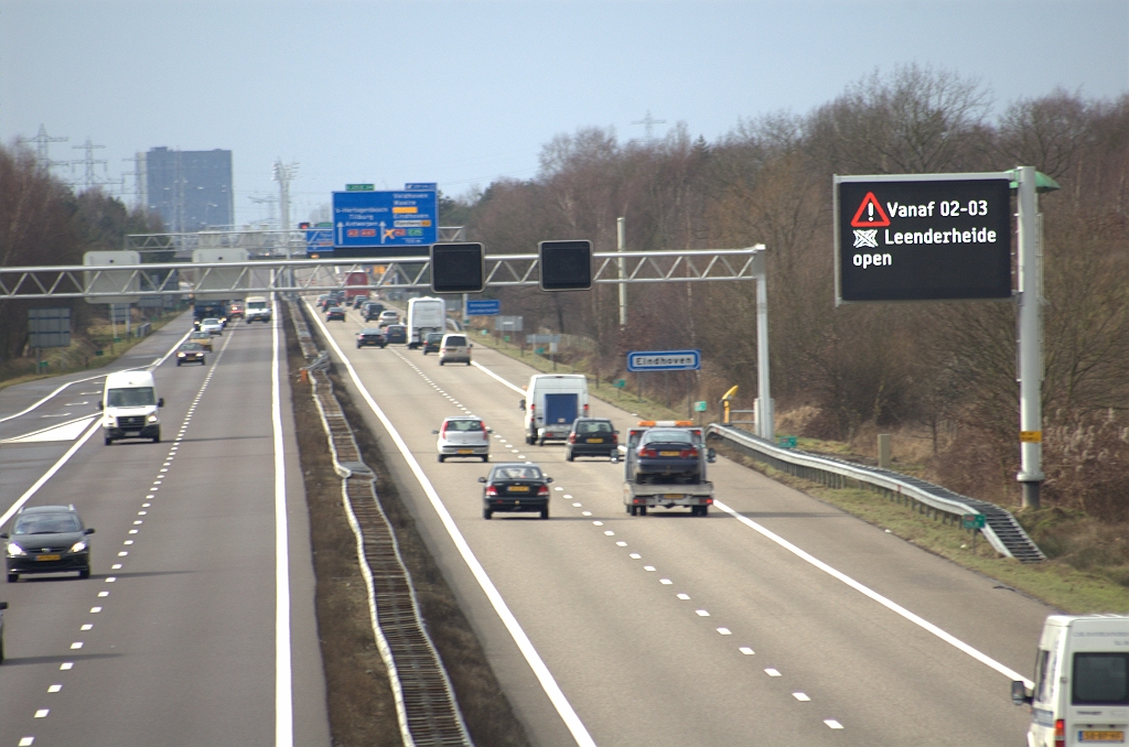 20100227-145359.bmp - Wat onscherpe foto van de A67 tussen de aansluiting Geldrop en het knooppunt Leenderheide. We hadden de camera dan ook laten focussen op het grafisch route-informatiepaneel dat een belangwekkende mededeling heeft. De openstelling was vorige week nog voorzien op 26 februari, maar moest worden uitgesteld wegens regen. Een voorspelling van drie weken geleden is uitgekomen: de oude mastborden zijn verwijderd (alhoewel er nog een lege mast staat) en vervangen door portaalborden. Agglomeratiebord ongewijzigd.  week 201005 