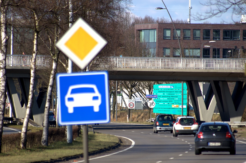 20100306-163653.bmp - Al langer geleden geplaatst bord G3 (autoweg) op de J.F. Kennedylaan, direct na de laatste afrit (Esp) binnen de kom. Methodiek in overeenstemming met de toeritten naar de Randweg N2, die ook autowegstatus hebben. Het miniparallelbaansysteempje in de aanslutingen Ekkersrijt en Helmond is eveneens autoweg. Enkel de toeritten die direct op de A50 hoofdrijbaan uitkomen krijgen autosnelweg status.