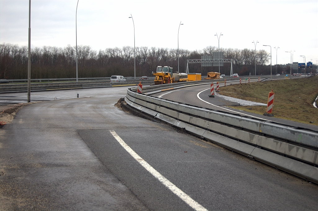 20100321-141210.bmp - Het lijkt een fasering te zijn om het verkeer van het te hoog liggende rijbaantje rechts af te krijgen. Die werd eerder in het project aangelegd voor faseringsdoeleinden, inclusief taludverbreding. Na aanpassing aan het uiteindelijke hoogteprofiel zou het dienst kunnen doen als vluchtstrook van een naar drie rijstroken te verbreden A58 in de richting Oirschot.