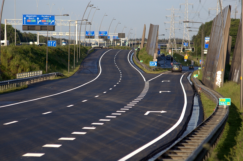 20100530-201944.bmp - Het strakke wegbeeld bij de aansluiting high tech campus is snel vergeten in de aansluiting Waalre met de karakteristieke golfbaanslingers tussen de kunstwerken. Op die kunstwerken zien we weer rijbaanbreed ZOAB met comfortabel overrijdbare hellinkjes in de CASTRO.  week 201020 