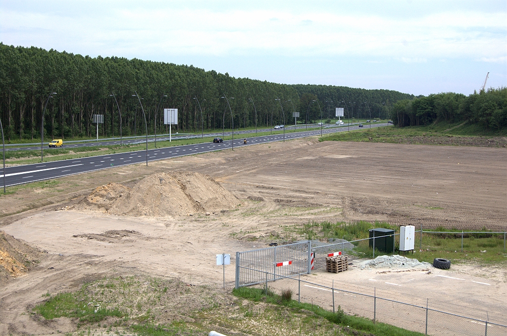 20100613-153841.bmp - Het gladgestreken sloopterrein moet samen met het ontboste driehoekje rechtsboven nieuwbouw van woningen mogelijk maken. Een buitenkans voor wie altijd al op een voormalig autosnelwegtrace had willen wonen. Geluidswal wordt daartoe verlegd en uitgebreid, maar daarvoor ligt het asfalt op de voorgrond nog in de weg...