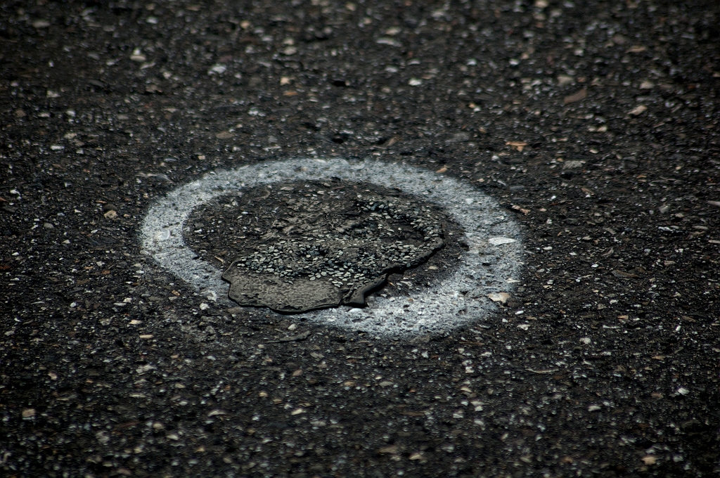 20110519-191104.jpg - Meerdere van deze wit omlijnde "blazen" op het viaduct. Hier is het asfalt plaatselijk omhooggekomen, maar werd al eerder provisorisch hersteld. In het huidige garantiewerk verdwijnen deze wonden dus met de complete vervanging van het asfalt.