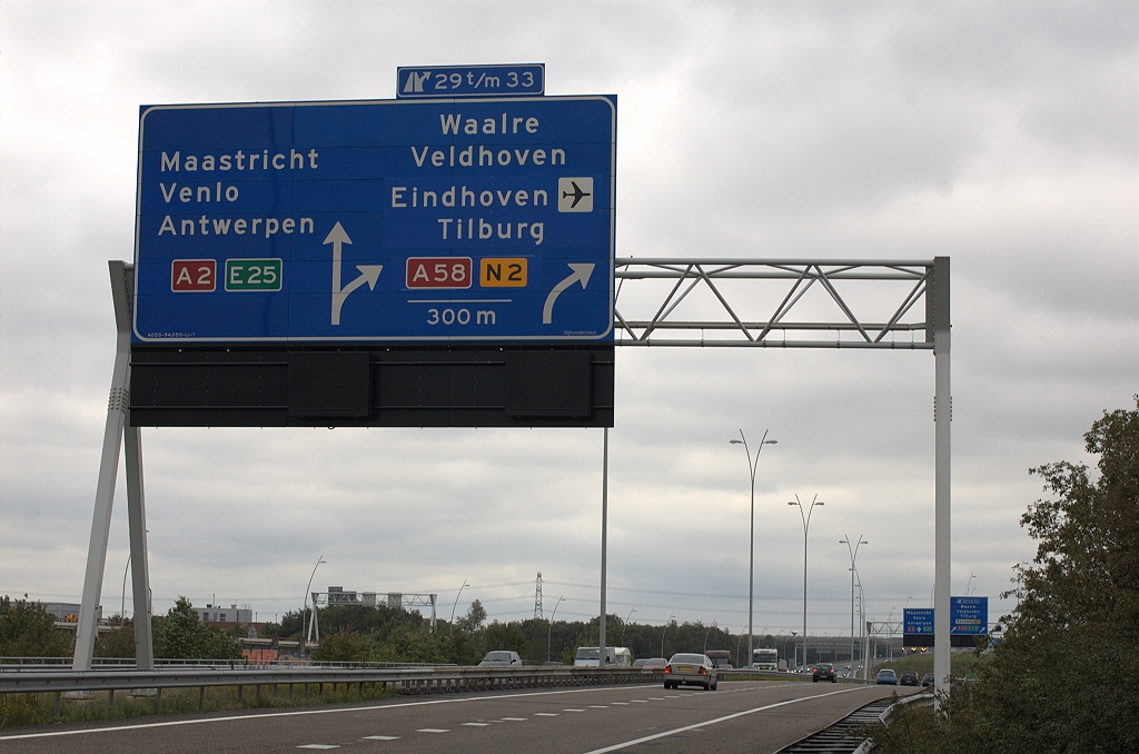 20101016-140800.bmp - Identieke wijzigingen op het tweede portaalbord. Men heeft dus Tilburg een regel naar beneden verschoven, en in de vrijkomende ruimte Eindhoven (met vliegveldsymbool) geplaatst. Dit ging ten koste van "Randweg N2", maar een N2 schildje onderaan vervangt dat. Dat schildje heeft de plek ingepikt van het E312 schildje. Dat is dan maar weggelaten, hoewel het als ruiter had gepast naast de afritnummers.  week 201015 