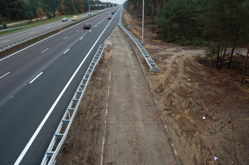20101106-152651.bmp - Aan de zuidzijde van het viaduct Heezerhut verraden bandensporen dat het hier mogelijk is de rijksweg te verlaten voorlangs de onderbroken geleiderail. Men komt aanvankelijk op een asfaltweg terecht parallel aan het talud naar het viaduct, maar zal onverhard verder moeten om bijvoorbeeld de N396 te bereiken.  week 201042 