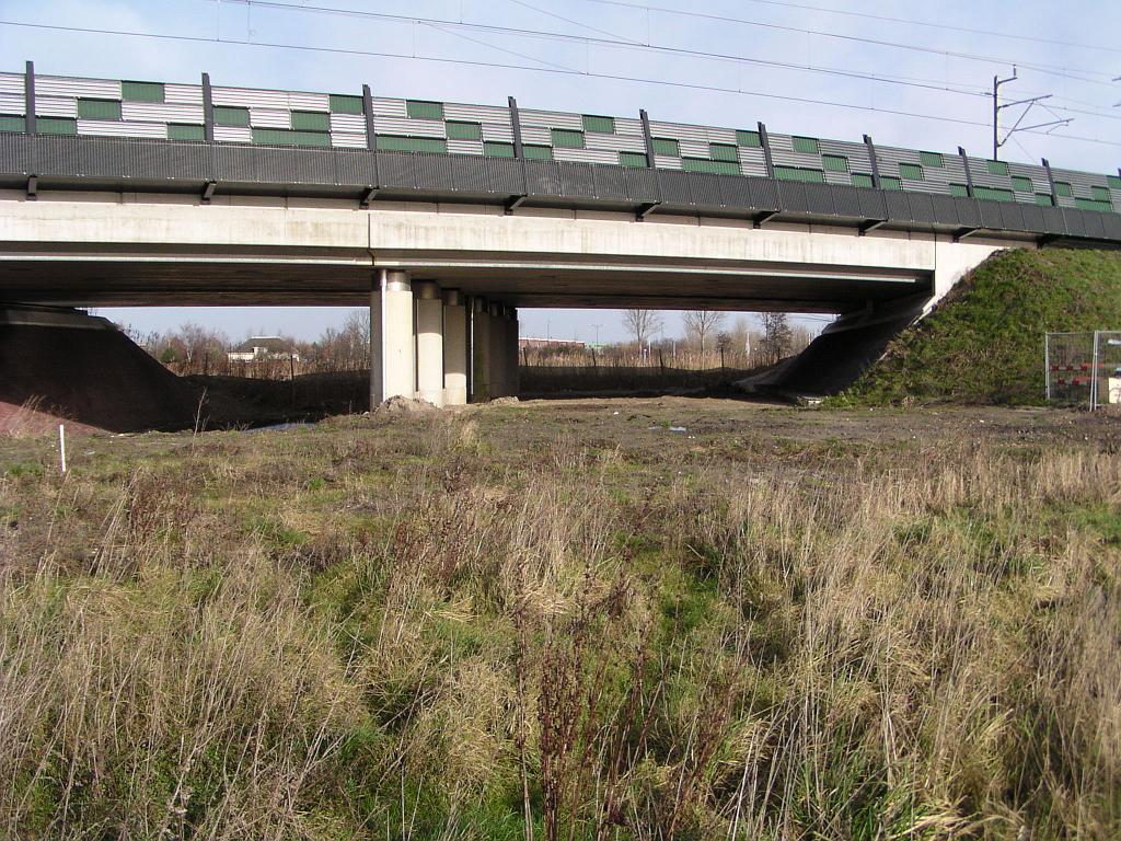 p1260046.jpg - Zuidzijde van het spoorviaduct. Een onnauwkeurige breedtemeting van de bruikbare ruimte met behulp van de voetstap methode leverde een resultaat op van 2x13 meter. Met een standaard rijstrook breedte van 3,5 meter en een vluchtstrook van 3 meter houden we dan nog ruimte over voor geleiderails.