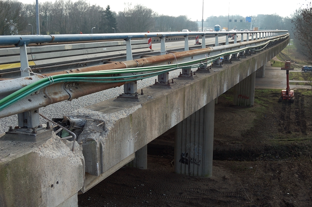 20110220-144810.JPG - Nog een typerend element in de bijzondere inpassing van de A50 Nederrijn-Grijsoord: het landviaduct Heelsum. Men heeft hier de betonbreker ingezet op het kunstwerk, zodat de oude wapening bereikbaar is geworden. We zien dit op alle vier de hoekpunten. Misschien ten behoeve van het vervangen van de voegovergangen. Tevens een groot aantal boorgaten te onderscheiden, die door personeel in hoogwerkers zijn aangebracht.