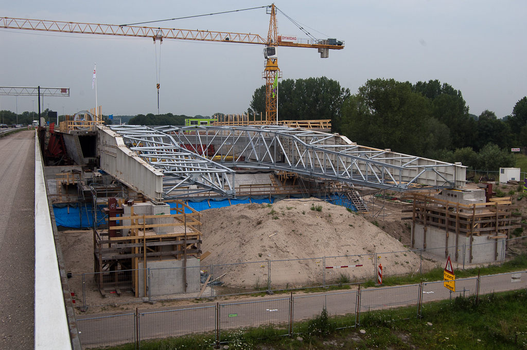 20110803-133115.jpg - Schuifarmen waarmee de betonconstructie beetje bij beetje richting rivier wordt verplaatst. De eerste schuifactie is recent voltooid. De voorzijde van de stalen schuifconstructie ligt nu op uiteindelijk weer te verwijderen betonnen steunen.