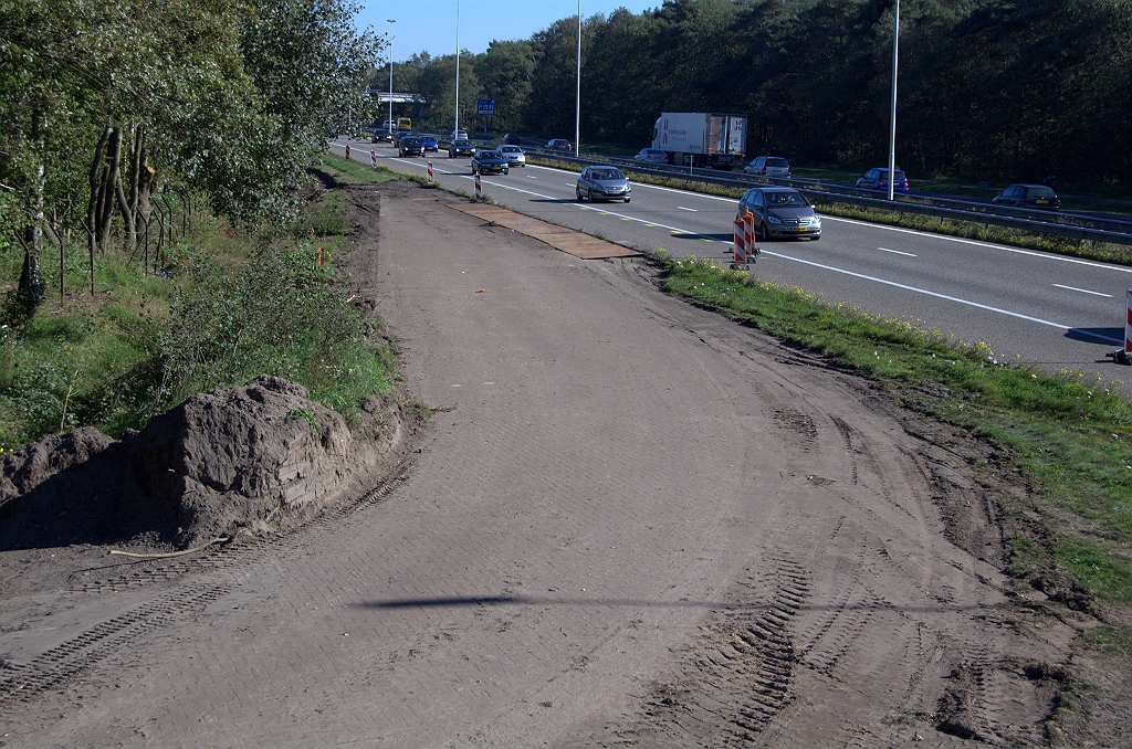 20101010-141240.bmp - Men is inderdaad verder gegaan met het verwijderen van de grasbegroeing, zodat nu duidelijk is dat de klinkerbestrating in de afrit vanuit Eindhoven tot vrijwel tegen de A58 rijbaan nog aanwezig is.  week 201039 