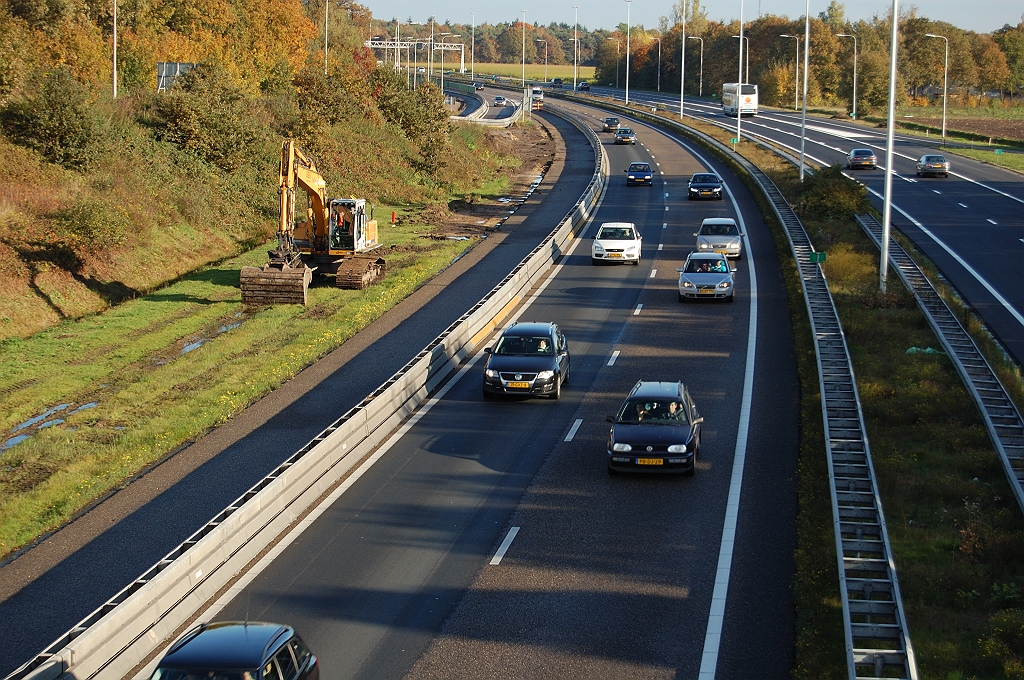 20101031-154500.bmp - Drie weken voor openstelling is er dan een graafmachine verschenen in het wegvakje tussen de afrit Oirschot en het viaduct in die aansluiting. Ook hier moet er worden verbreed, omdat de vermalling naar twee rijstroken net na de afrit inzet.  week 201035 