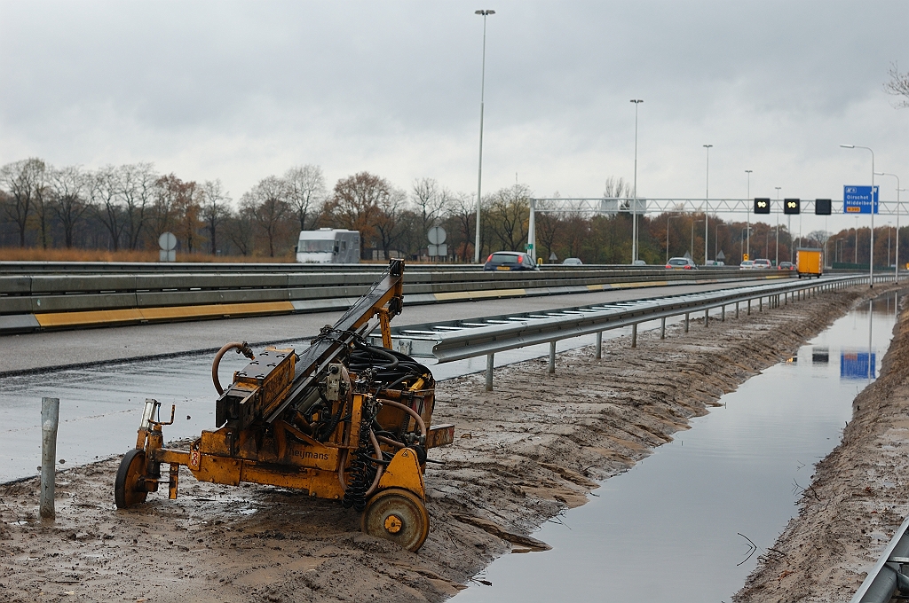 20101114-142729.JPG - Geleiderailsteunheimachine in de standby-stand. Hopelijk verdrinkt hij niet in de nieuw aangelegde bermsloot, die goede diensten bewees in de regenbuien van half november 2010 die in Limburg overstromingen tot gevolg hadden.