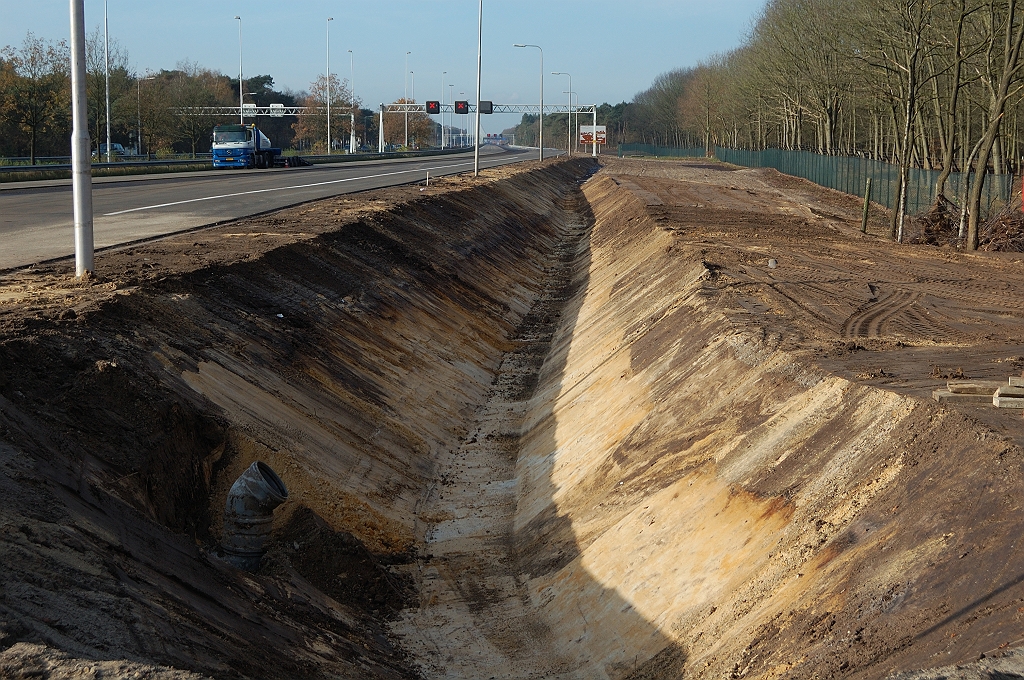 20101120-113608.jpg - Er moet hier flink zijn gerooid. Behalve het ruimtebeslag voor de verbreding is er ook nog eens een (voor Brabantse begrippen) forse bermsloot aangelegd, en rechts daarvan een ogenschijnlijk nutteloos niemandsland ontstaan. Het hekwerk van het militaire terrein zal dan ook verplaatst zijn.