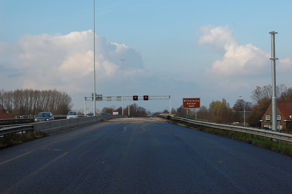 20101120-132549.jpg - Nog nauwelijks bekomen van de versmalling van drie naar twee rijstroken moet de A58 gebruiker ook het plaatselijk verdwijnen van de vluchtstrook op de brug over het Wilhelminakanaal trotseren. Nieuwe mast geplaatst, waaraan vast de nog ingepakte lamellen van foto 12 terecht zullen komen.