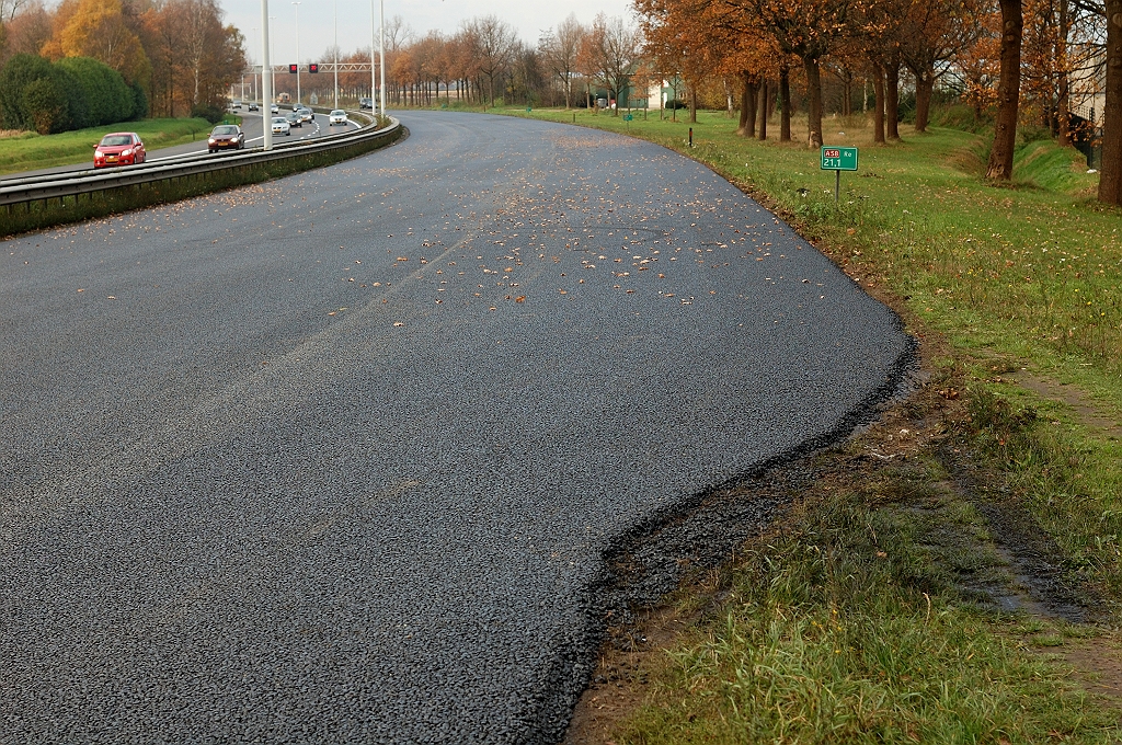 20101120-133615.jpg - Op het punt waar de voormalige toerit convergeerde met de hoofdrijbaan verwijdt die zich, en is op zaterdag ook volledig voorzien van de eerste ZOAB laag. Het lijkt erop dat bij de verwijdering van de oude toerit, ook een strookje van de hoofdrijbaan is verdwenen.