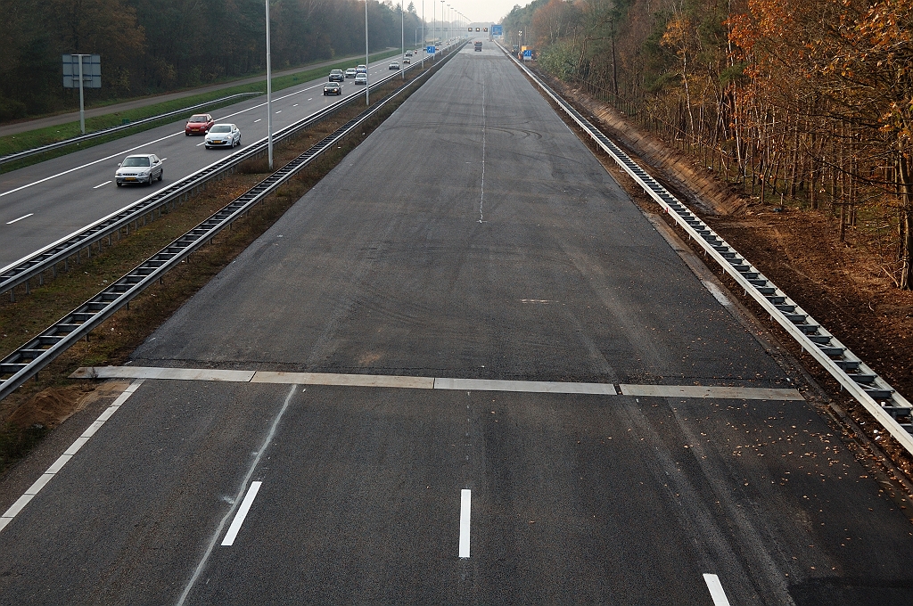 20101121-141249.jpg - Eerste van twee ZOAB deklagen aangebracht op de zondagmiddag. Het wegvak terug naar Best is reeds rijklaar en de overgang is beschermd met platen.