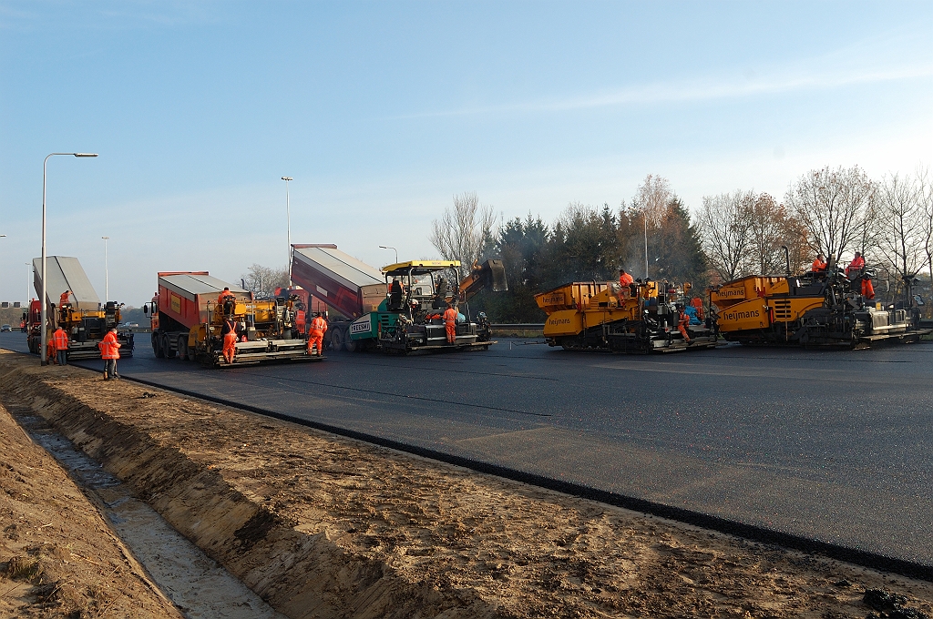 20101121-144125.jpg - ...maar verderop waar de afrit divergeert waren dat er nog vijf. Nog net zichtbaar de zwaai-arm van de shuttle buggy, die zo te zien de spreiders in de rijstroken 1 en 2 bedient. Als we een gokje mogen wagen dan is de reden daarvoor dat die het moeilijkst bereikbaar zijn voor de asfalttransporten.