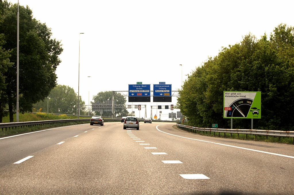 20090503-140600.jpg - Op 21 april 2009 werd de DYNAMAX proef op de A58 ten zuiden van Tilburg actief. De snelheidslimiet gaat daarbij omlaag als het voorspelde daggemiddelde voor fijnstof boven de norm dreigt uit te komen. We rijden hier vanaf het knooppunt de Baars in de richting Breda en ontwaren het veelkleurige aankondigingsbord bij km 34,5.