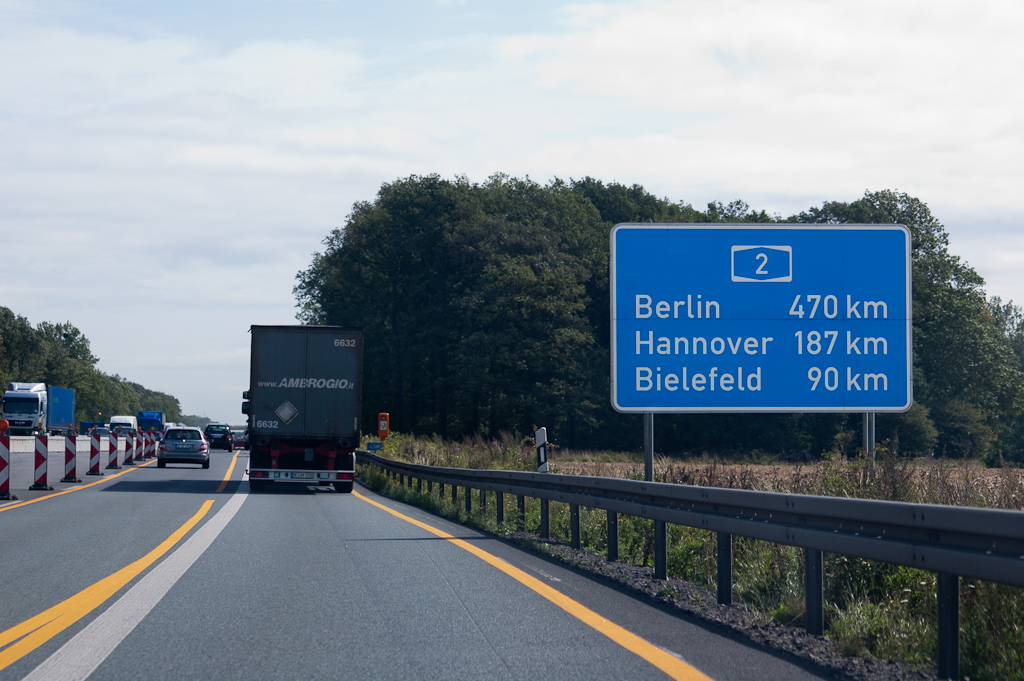 20110811-101013.jpg - ...en het bijbehorende afstandenbord na het passeren van het knooppunt. Het hectometerbordje in de verte toont de waarde 409, zodat je steeds 60 km moet optellen bij de HMP waarden om te weten hoe ver je nog van Berlijn verwijderd bent. Werkzaamheden (Baustelle) hier. Het is de verbreding tot 2x3 rijstroken van het A2 wegvak tussen kp. Kamen en de aansluiting Hamm. Het ongeveer 10 km lange wegvakje is het enige in de ruim 470 km lange A2 dat nog 2x2 was.