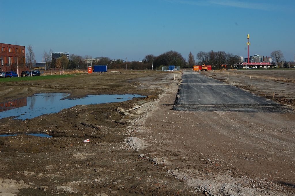 20110320-150715.JPG - Verder westwaarts. Het nieuw gedraaide asfalt is geen onderdeel van de verlengde Meerhovendreef, maar is een erftoegangsweg in de nieuw te bouwen woonwijk "het Groene Hof". Het trace van de Meerhovendreef ligt ingeklemd tussen die nieuwe wijk en de bestaande wijk Grasrijk, waarvan uiterst links nog woningen te zien zijn in de foto.