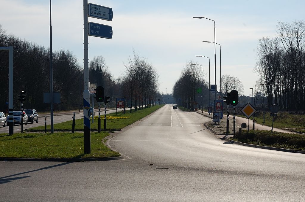 20110320-153916.JPG - Ten tweede wordt men bij het verlaten van de rotonde geconfronteerd met fiets-en voetgangersoversteekplaatsen, waar met drukknoppen wordt aangemeld. Hier gezien in de richting Heerbaan, ontsluiting van de wat oudere wijken in Veldhoven. 2x2 rijstroken en Vmax 70 over enige kilometers.