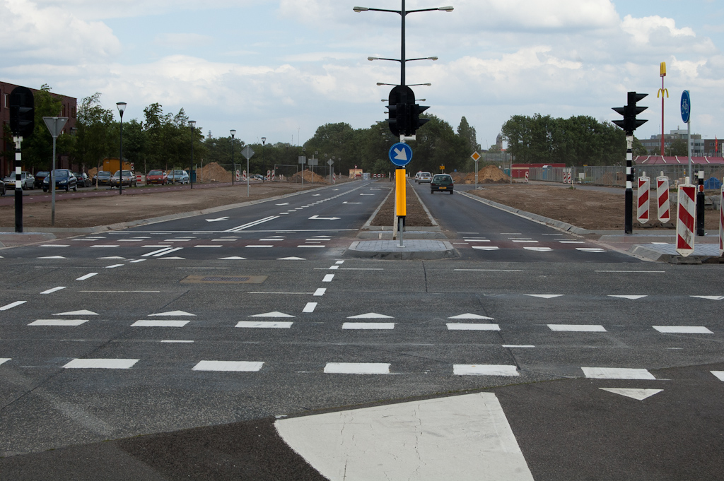 20110522-134134.jpg - Nog wat details toegevoegd in de laatste week voor openstelling, zoals het zuiltje in de middenberm en printbeton in de vluchtheuvels. De toegevoegde onderbroken markering links lijkt niet overbodig. Vooral verkeer dat linksaf slaat vanaf de verlengde Meerhovendreef naar de Grasdreef (rechts op de foto) heeft soms moeite het juiste parcours te volgen.  week 201119 