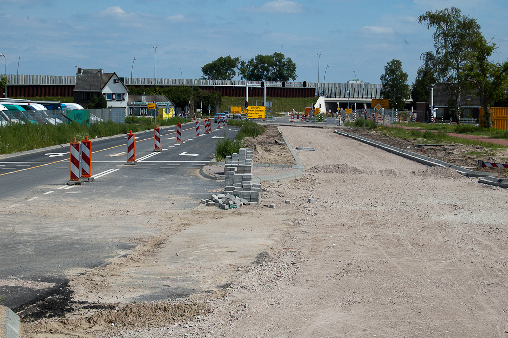 20110703-142241.jpg - Nog geen asfalt op de zuidelijke rijbaan van de Heistraat. Het lijkt erop dat men de hernieuwde kruising met de ontsluitingswegen naar de (thans nog) vier bedrijven integraal wil meenemen.  week 201125 