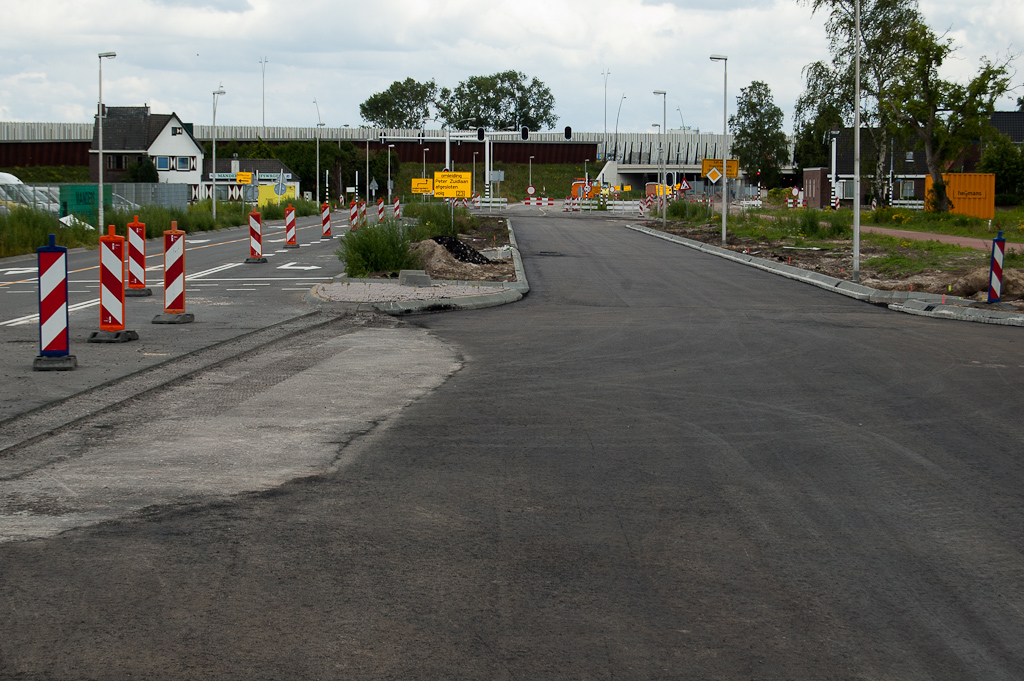 20110717-160539.jpg - Nieuw asfalt op de zuidelijke rijbaan van de Heistraat, inclusief ontbrekend gedeelte in de nieuwe kruising ter ontsluiting van tankstation, garagebedrijf en hotel. Aan de klinkergoot rechts is te zien dat er nog zeker twee lagen bovenop moeten.  week 201126 