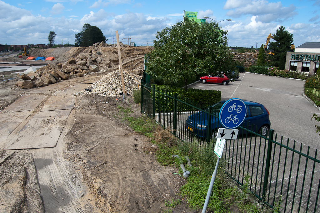 20110828-134108.jpg - Voortgaande om-muring van het hotel Campanile in de oostelijke oksel van de Hovenring kruising. De reden dat het dijklichaam voor het fietspad zo ver wordt doorgetrokken is niet duidelijk. Er komt immers geen fietsverbinding aan de noordzijde van de Heistraat. Het verkeersbord G12a is een relikwie van de oude situatie.