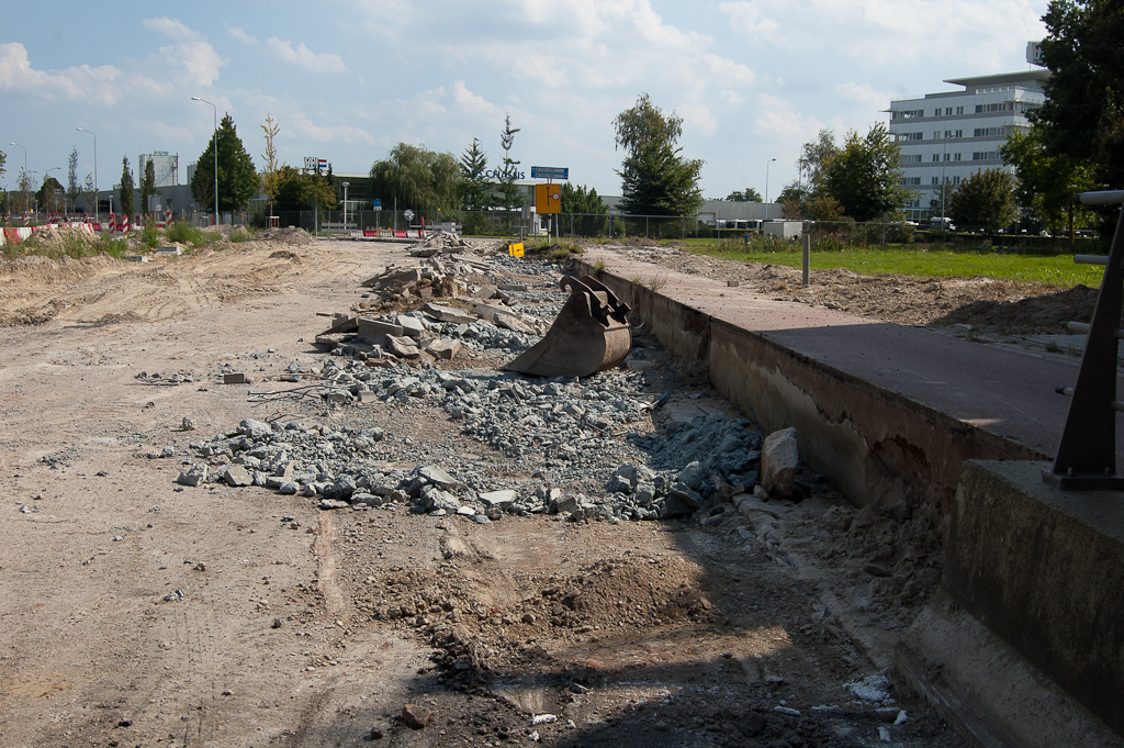 20110903-135013.jpg - Die zuidelijke rijbaan, van viaduct tot en met de kruising met de Hoevenweg, is meteen gesloopt. Vervolgens heeft de betonnen grondkering tussen fietspad en verdiepte rijbaan er aan moeten geloven. Reden daarvoor is duidelijk: hier moet de afrit vanuit de richting Maastricht worden gerealiseerd.