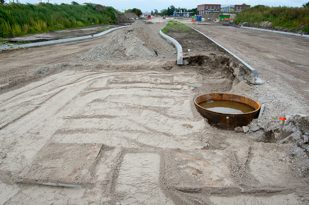 20110911-113518.jpg - Een aantal provisorisch afgedekte betonnen putten in de onmiddelijke nabijheid van een buispaalfundering voor het voertuigkerende portaal in de Grasdreef. Is er een verband?  week 201135 