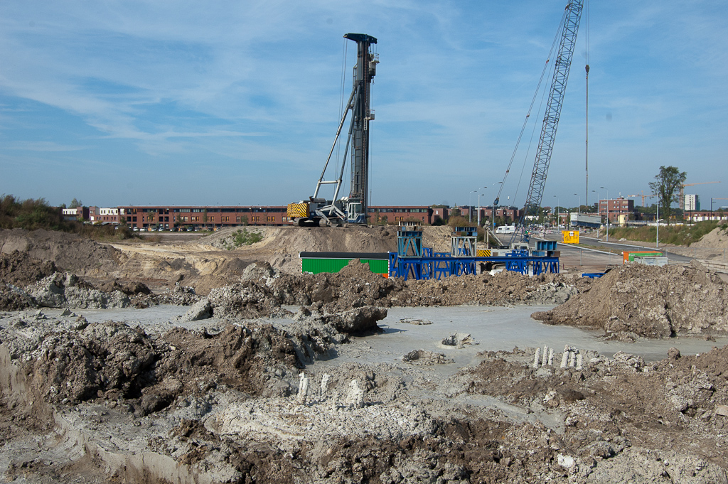 20110924-120638.jpg - ...het is duidelijk dat hier die wapeningscylinders zijn ingeboord. Een oude bekende, de Woltman 7528, is daarmee nog bezig in het westelijk hoekpunt. De aanbruggen van de fietsrotonde krijgen dus een solide fundering. Samen met de steunen vanuit maaiveld op de hoekpunten zou je dan denken dat de rotonde ook zonder pyloon en tuien al stevig op zijn plaats zit.