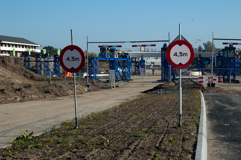 20111023-144618.jpg - Voor het werkverkeer zijn thans verkeersborden en werkportalen met schrikplanken geplaatst. In de eindsituatie verwachten we enkel nog de blauwe rechthoekige hoogtebeperkingsbordjes ten behoeve van uitzonderlijke transporten. De legale voertuighoogte voor regulier verkeer bedraagt immers maximaal 4 meter.