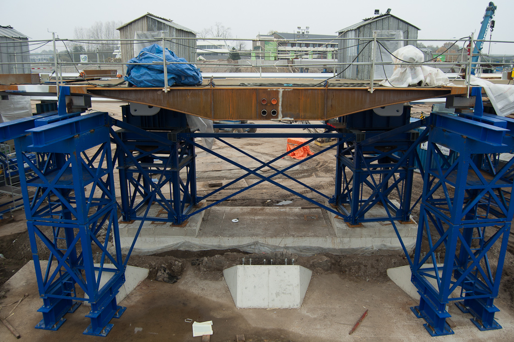 20111106-140510.jpg - Tweede van vijf staaltransporten heeft de afgelopen week plaatsgevonden, en we zien dan ook een nieuw brugdeel tussen Grasdreef en Heerbaan. Dit is een plek waar een aanbrug moet worden bevestigd, zodat je vanaf het dijklichaam in de westzijde van de Hovenring (standpunt) de rotonde op kunt fietsen. De vier cirkeltjes in het brugdeel lijken mantelbuizen te zijn, wellicht voor de verlichting.  week 201143 