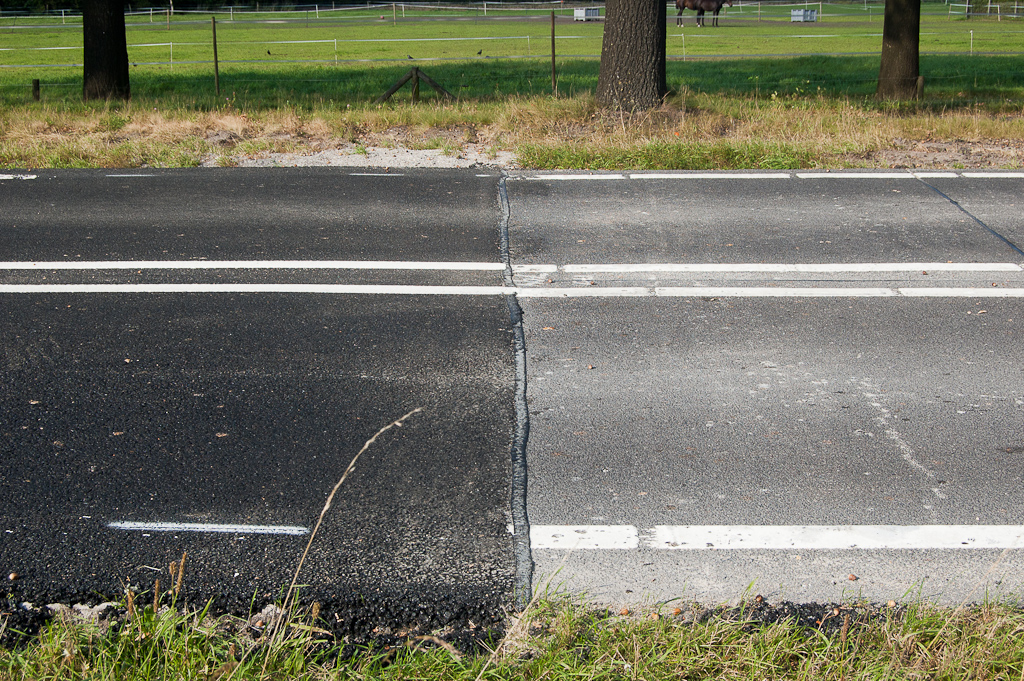 20110925-150408.jpg - Hier dus een overgang van verschillende asfalt-overlagingen qua ouderdom, maar wellicht ook naar type. De bestaande overlagingstechniek rechts heeft flexibele voegen boven de naden in het onderliggende beton. In het recente project is doorgaand overlaagd.  week 201137 