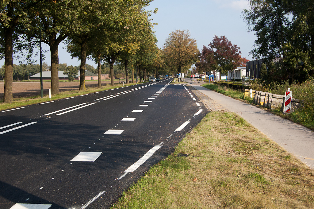 20110925-151451.jpg - Afrit naar het bedrijventerrein "De Sleutel" in Bladel met onderbroken kantmarkering voortgezet in die afrit. Fietspad blijft van beton.