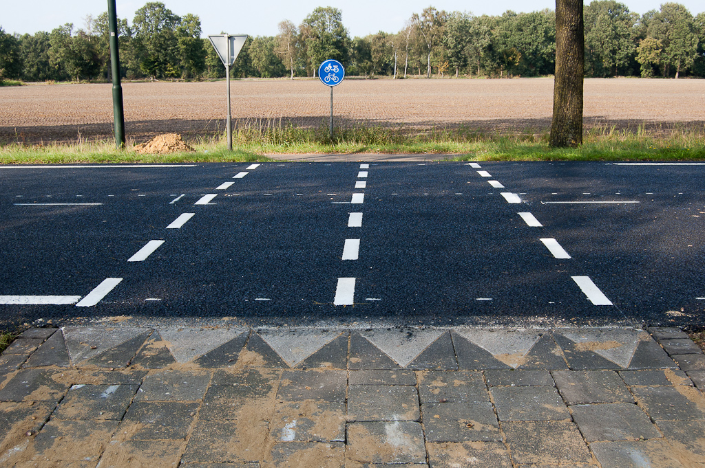 20110925-151719.jpg - Fietsoversteek bij "De Sleutel" waarvan je je kunt afvragen of hij bij een "echte" Duurzaam Veilige verbouwing was gehandhaafd, althans in deze vorm. Het DV karakter van het nu voltooide N284 project tussen Reusel en Hapert lijkt zich te beperken tot de markering. Ook de maximum snelheid (80 km/u) blijft ongewijzigd. Fietspad-oprit enigzins verhoogd zodat het vlak aansluit op de asfalt-overlaging op de rijbaan.