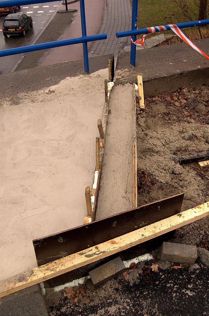 20081130-131734.jpg - Een smal reepje beton op het landhoofd. Tussen dat reepje en de stoep op de bovenbouw van het viaduct is met schotjes, latjes en schuim een uitsparing gemaakt voor de voegovergang.
